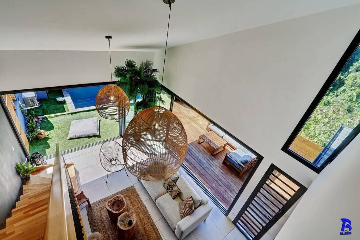 Vue depuis le haut de l'escalier sur le salon et la piscine