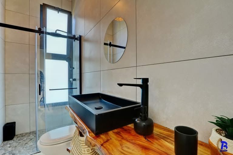 Salle d'eau moderne avec vasque noire et douche à l'italienne