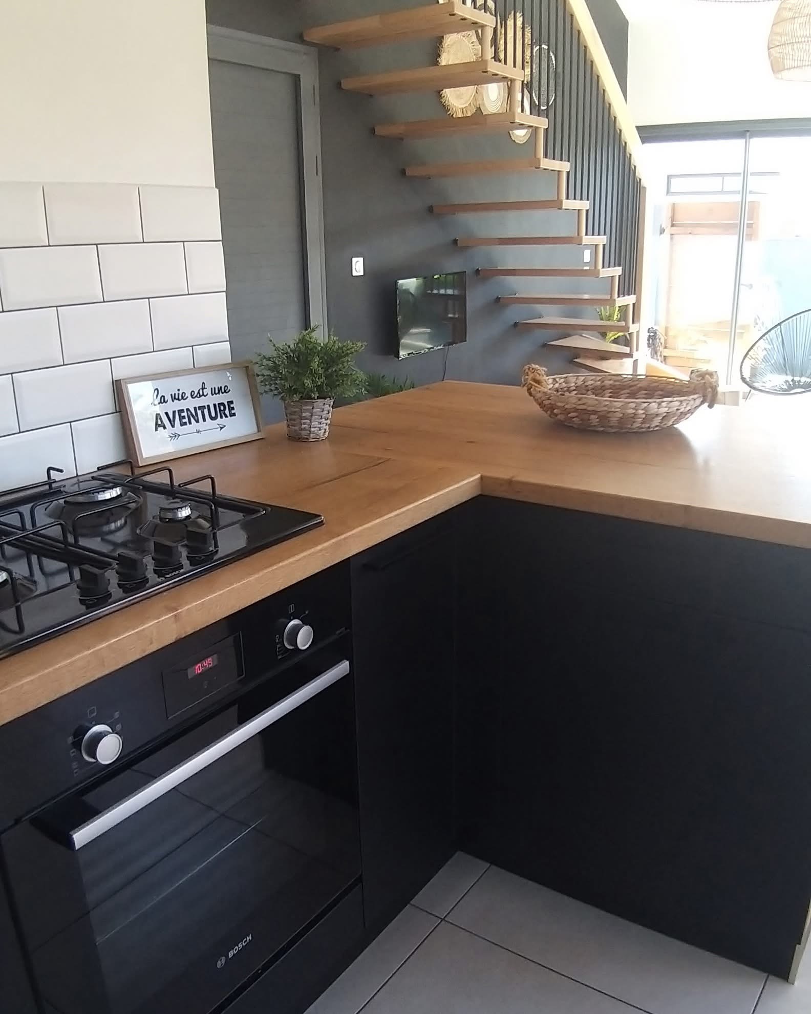 Cuisine équipée avec plaque gaz, four et plan de travail en bois