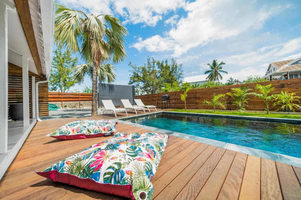 Terrasse en bois et coussins tropicaux près de la piscine