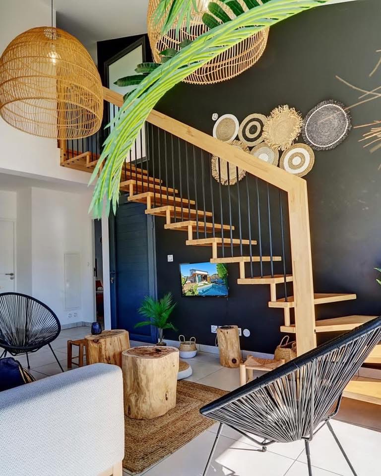 Escalier en bois suspendu devant un mur anthracite décoré